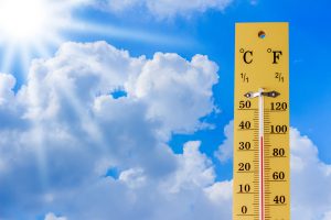 A thermometer reaching high temperatures outside.