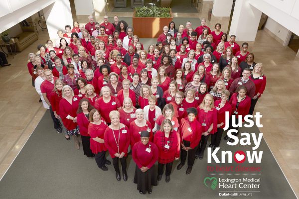 "Just Say Know to heart disease" flyer of hospital employees in red scrubs standing together to form a heart shape