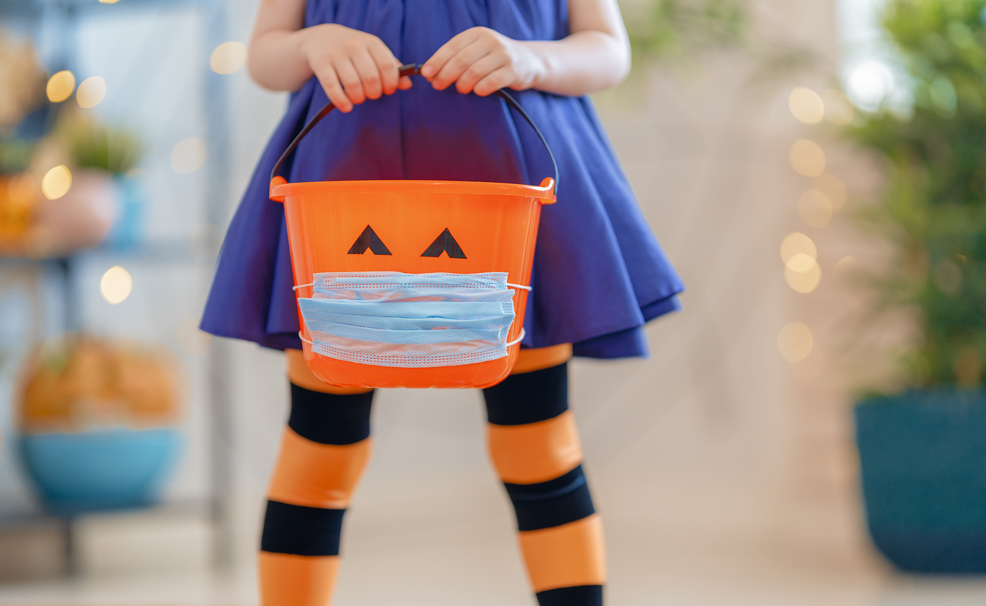 Child with Halloween candy basket wearing mask