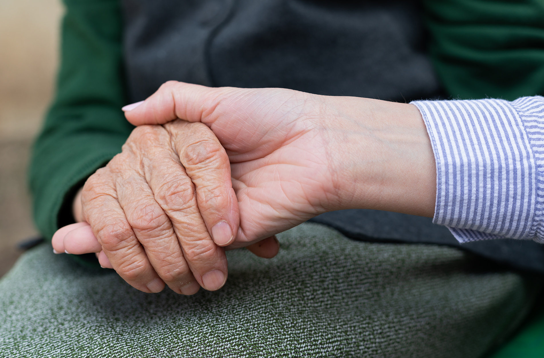 Young hand touching elderly hands