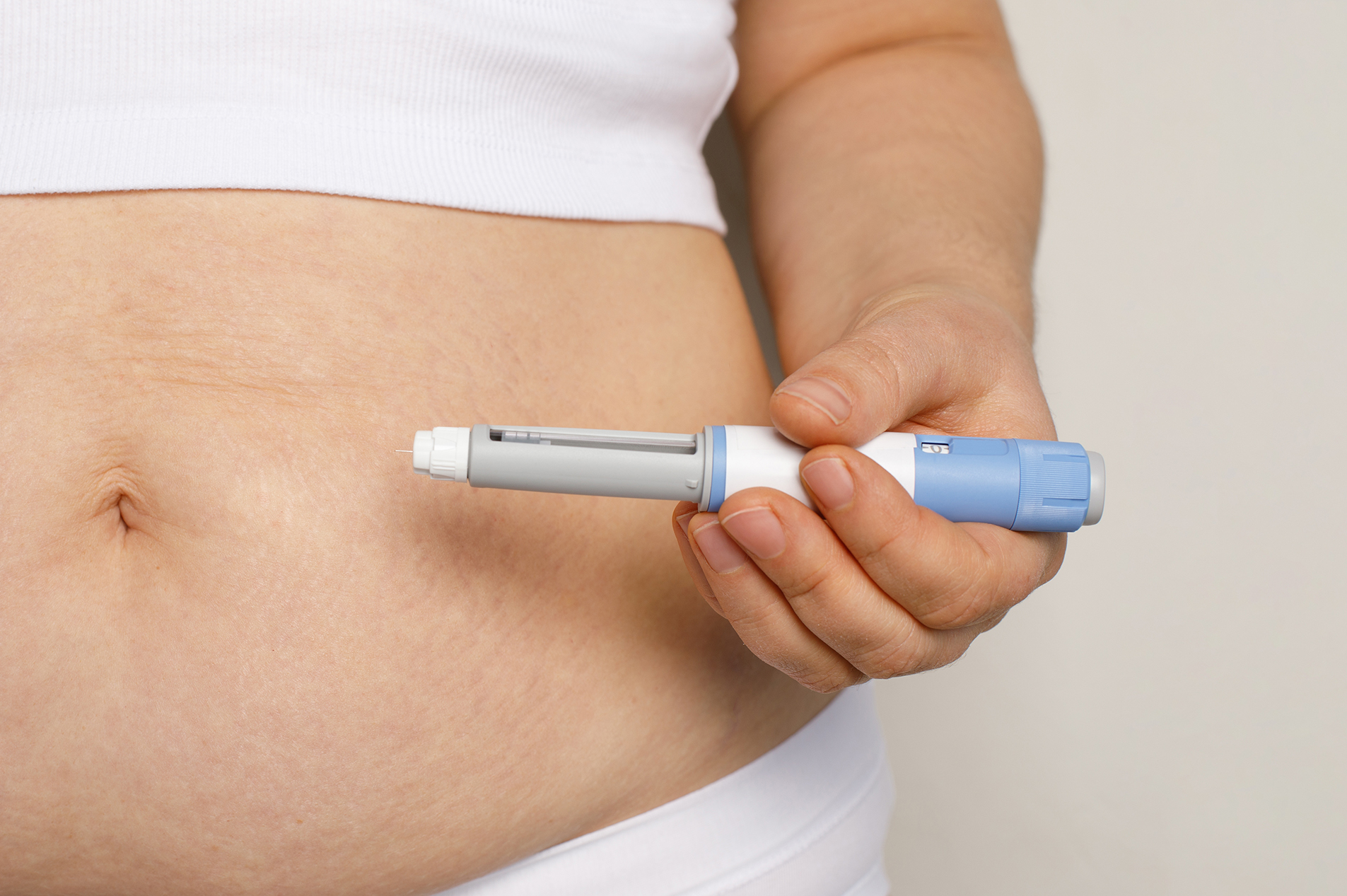 Woman preparing to give herself GLP-1 injection in stomach
