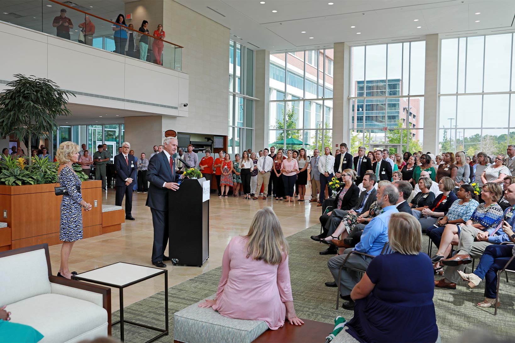 Governor Henry McMaster at a podium giving a speech in the lobby of Lexington Medical Center to an audience.