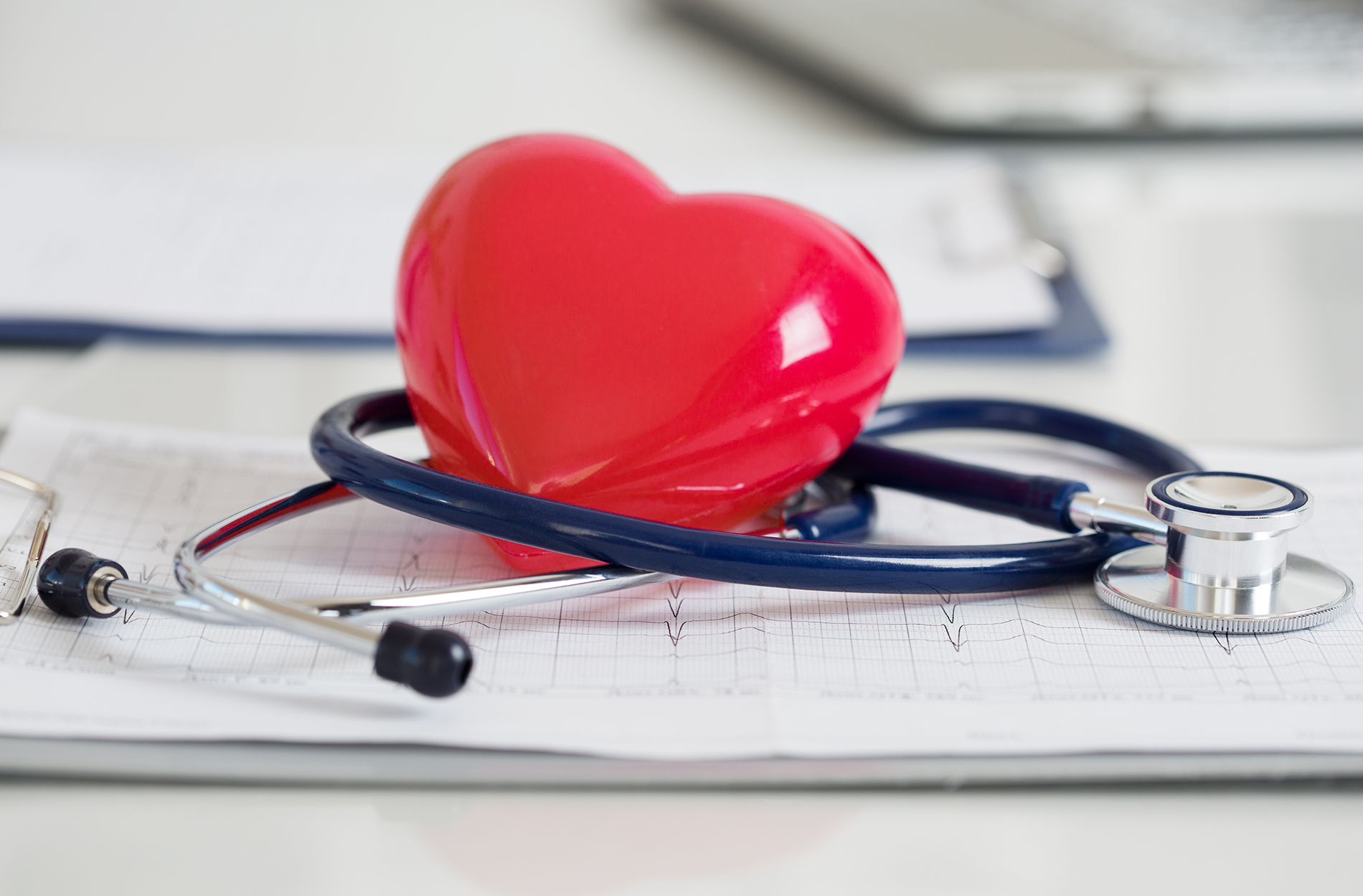 Red heart and stethoscope on physician clipboard