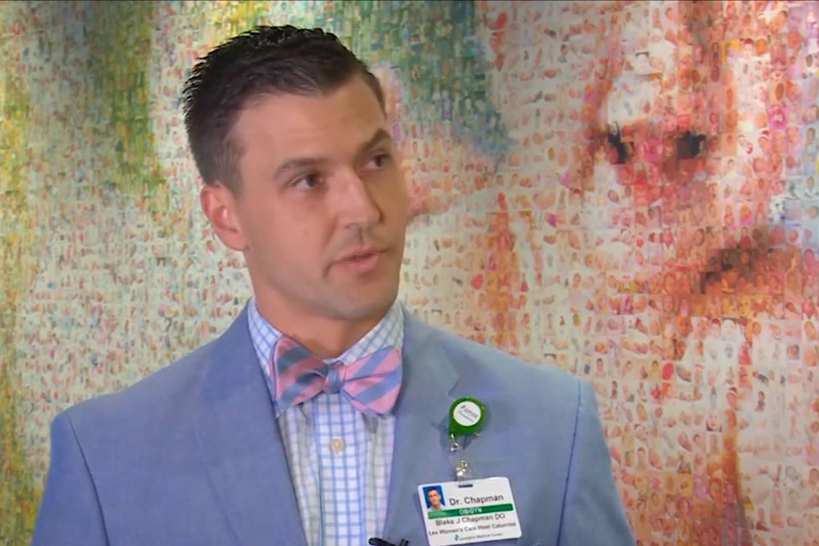 Dr. Chapman having a conversation in front of the baby mosaic of the new patient care tower.