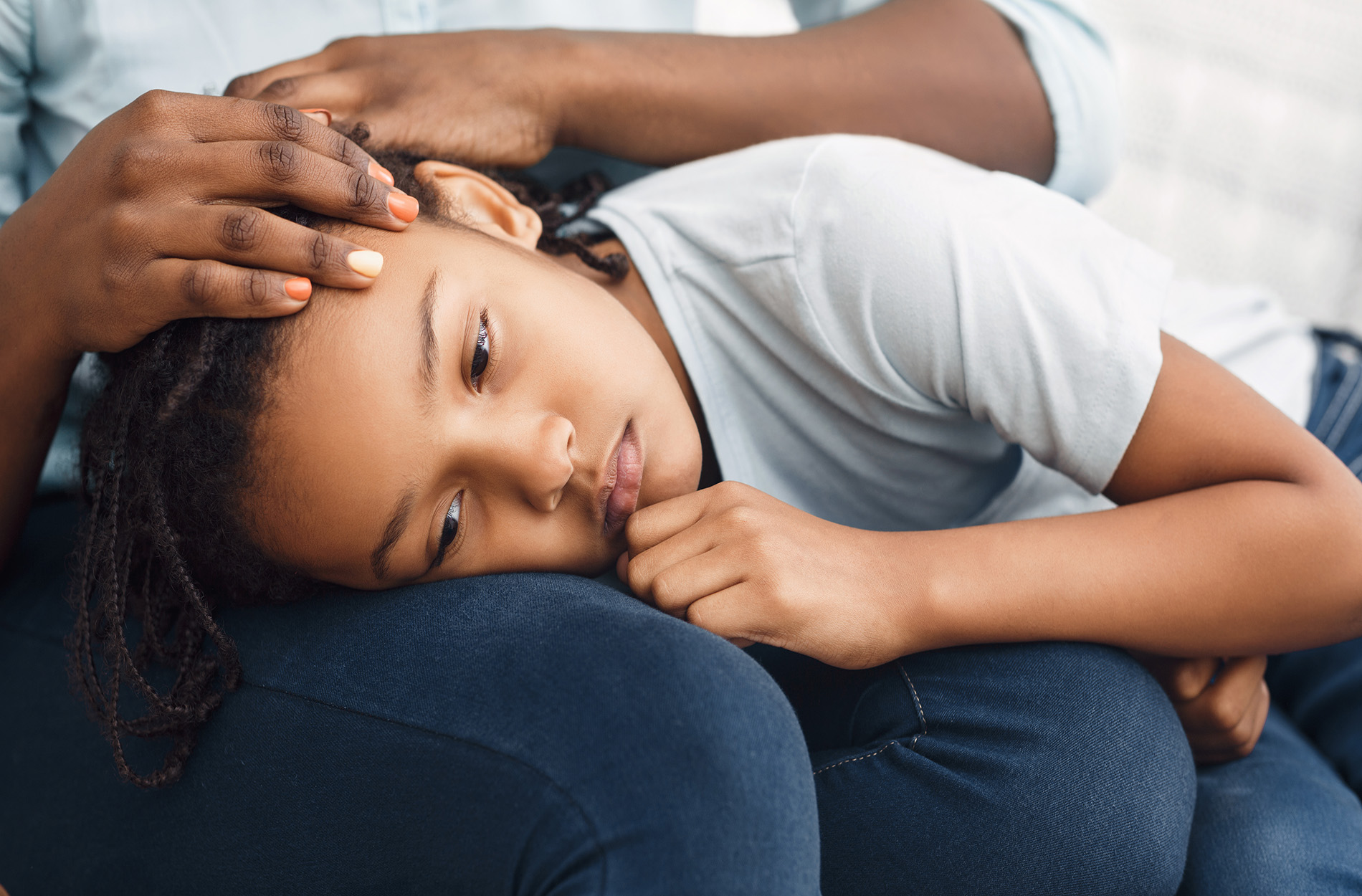 Sad girl with head on mother's lap