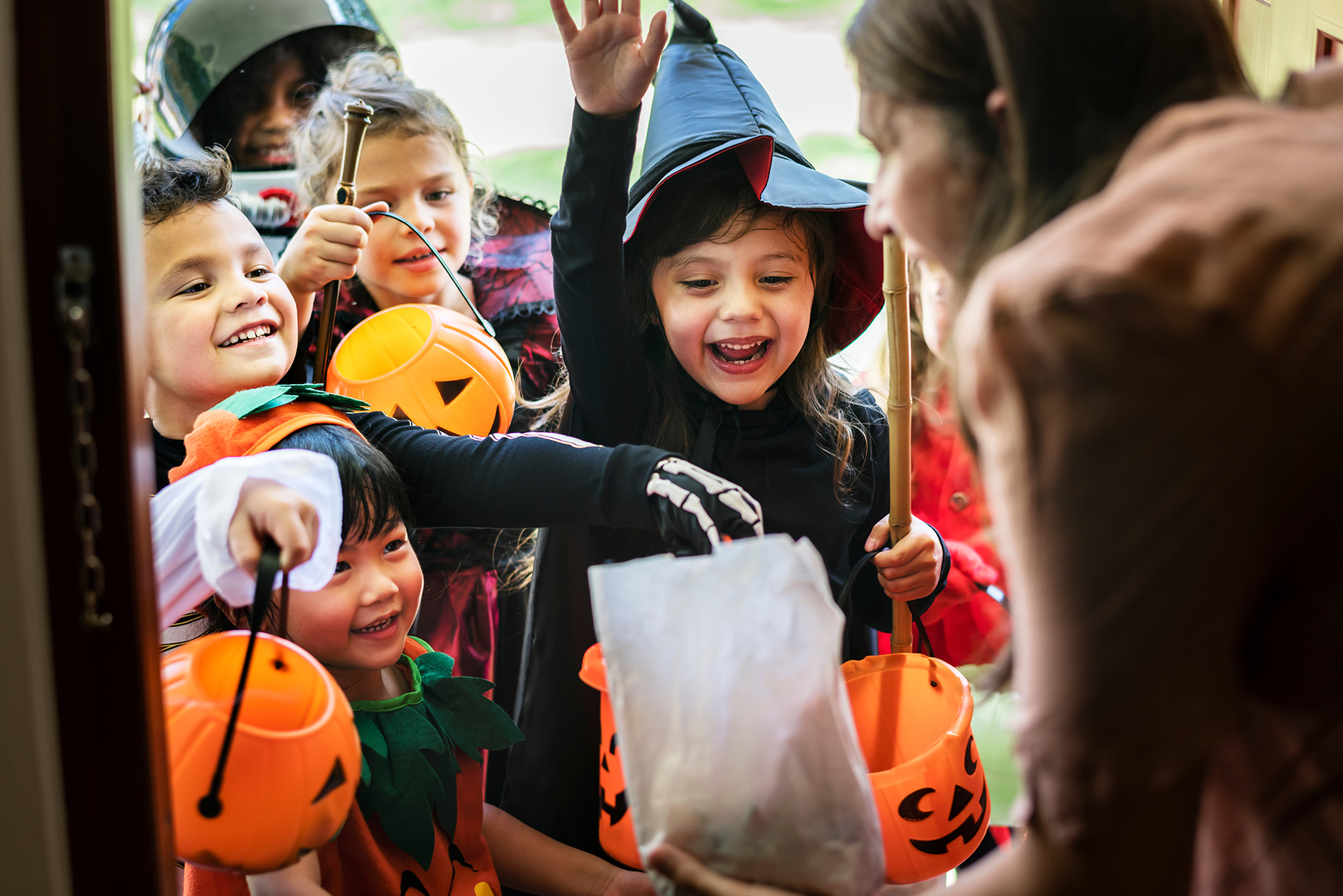 Group of children in costumes trick or treating at Halloween