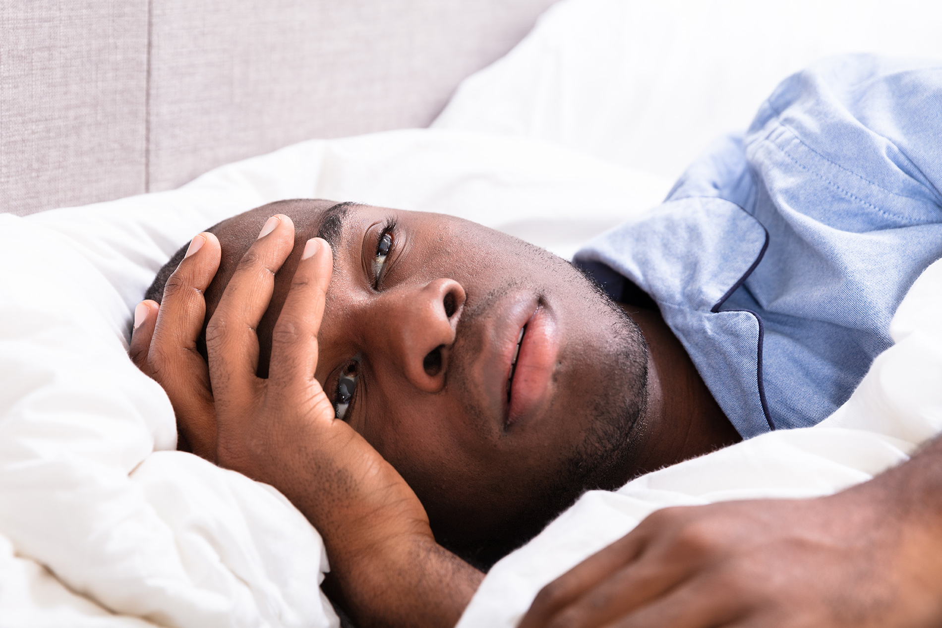 Man lying on bed sick