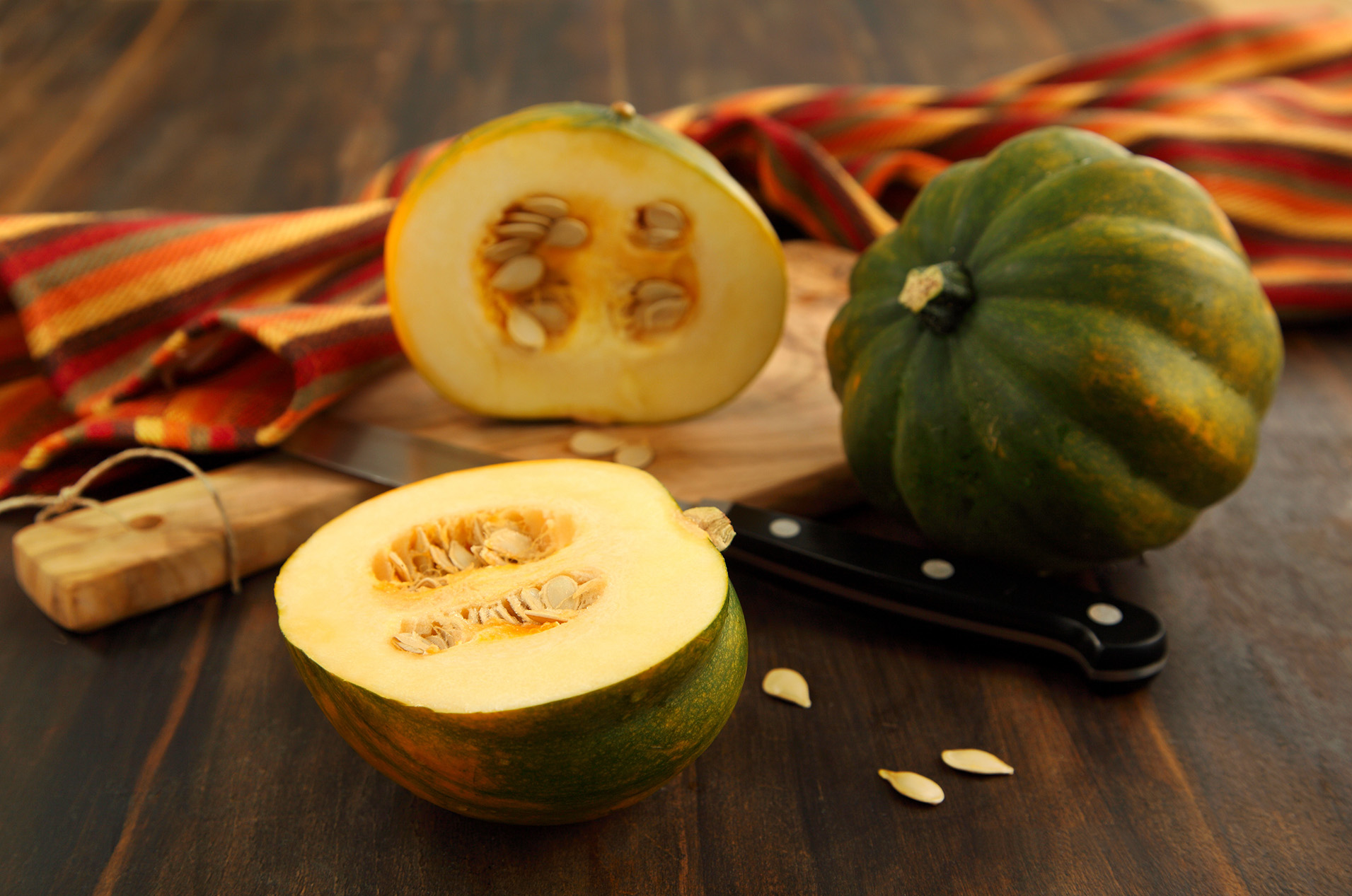Whole and cut acorn squash on cutting board