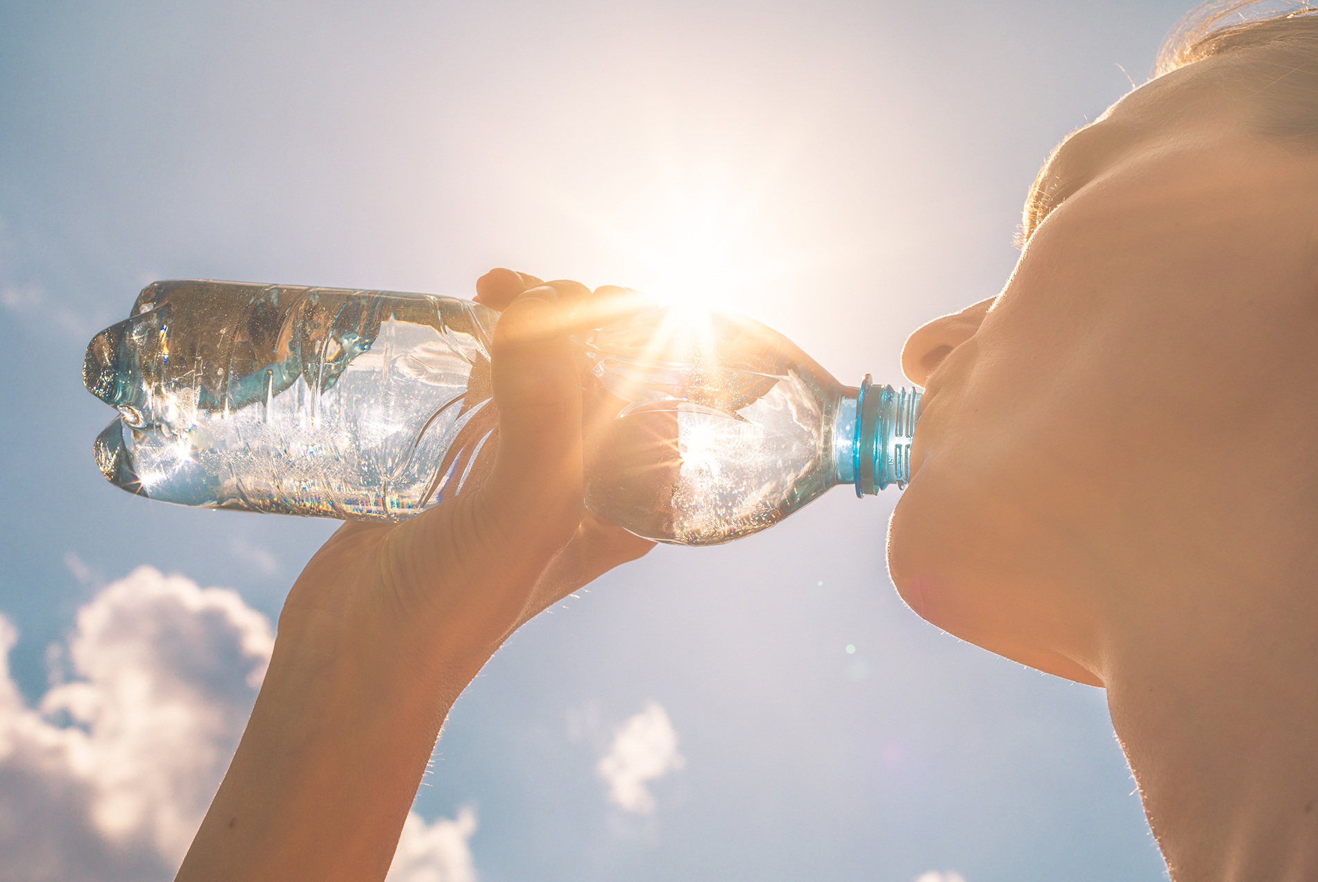 Women drinking bottle of water in sunshine