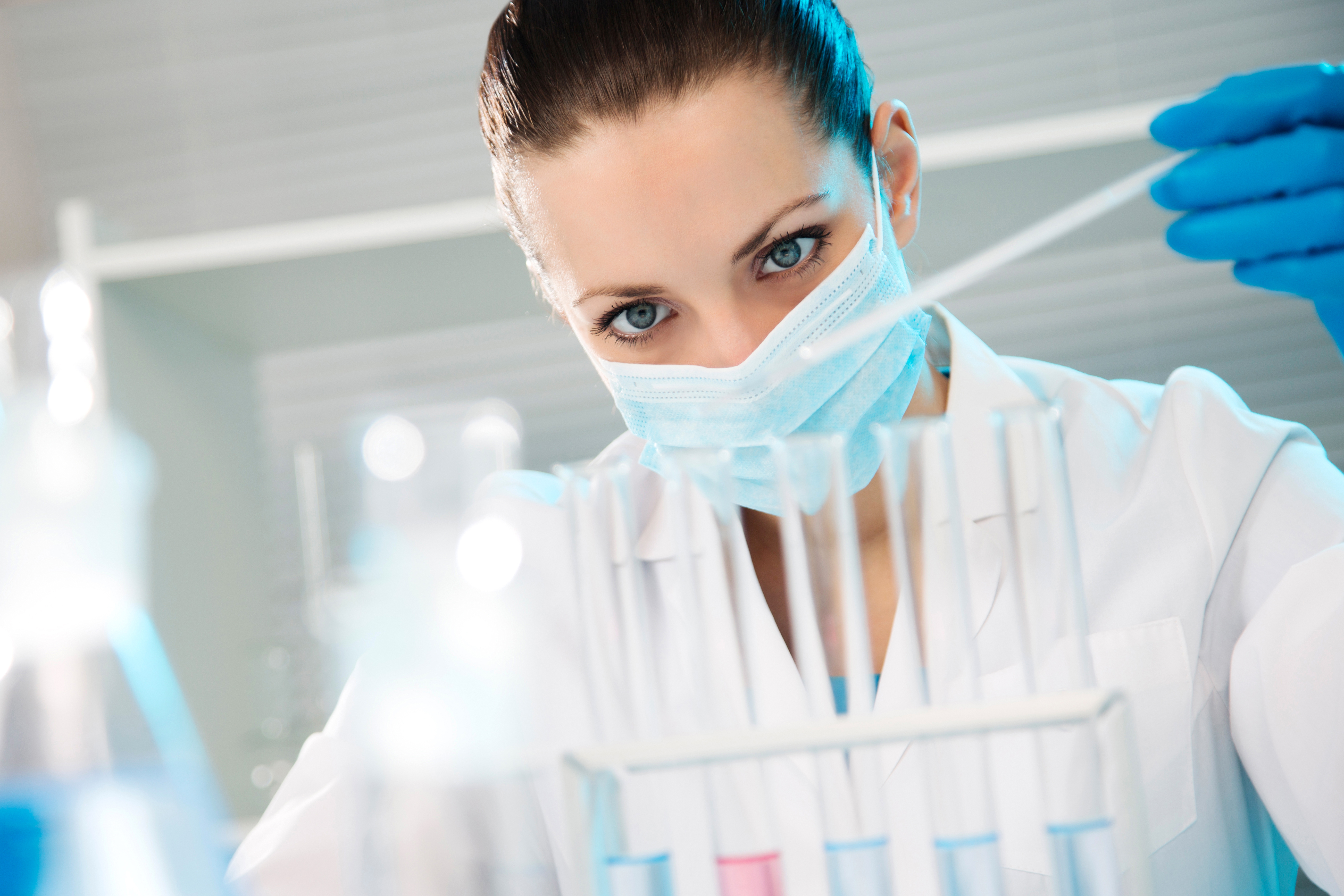 Lab technician performing lab test with vials of liquid