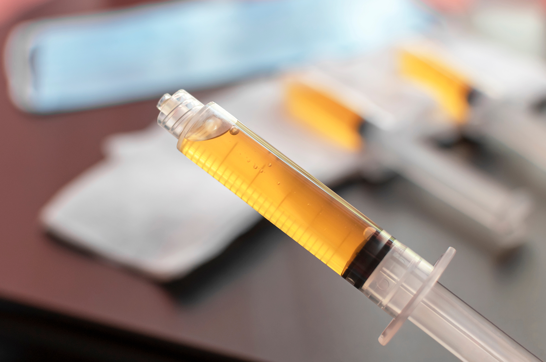 Medical professional holding syringe of platelet-rich plasma