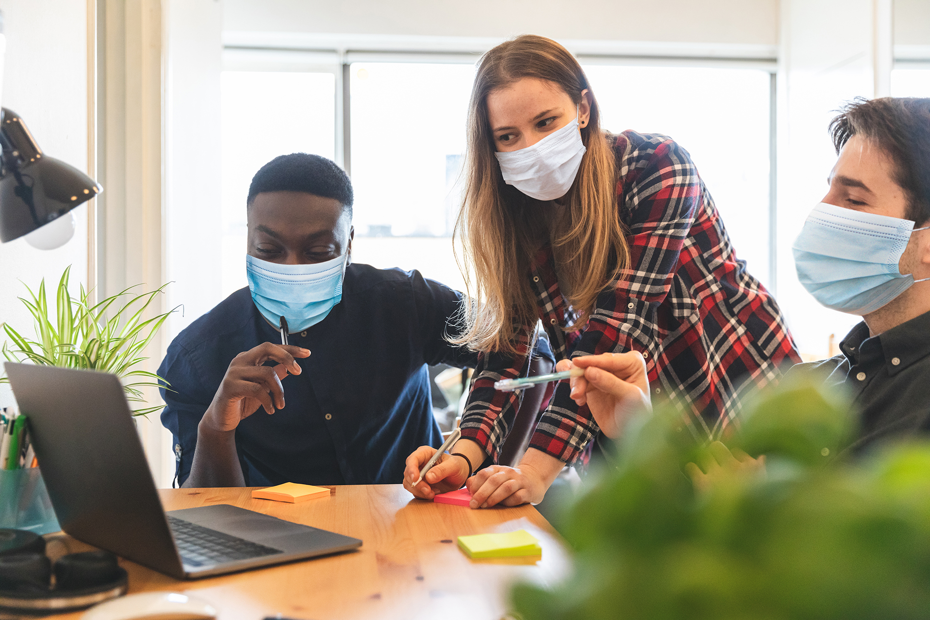 Three office workers wearing masks