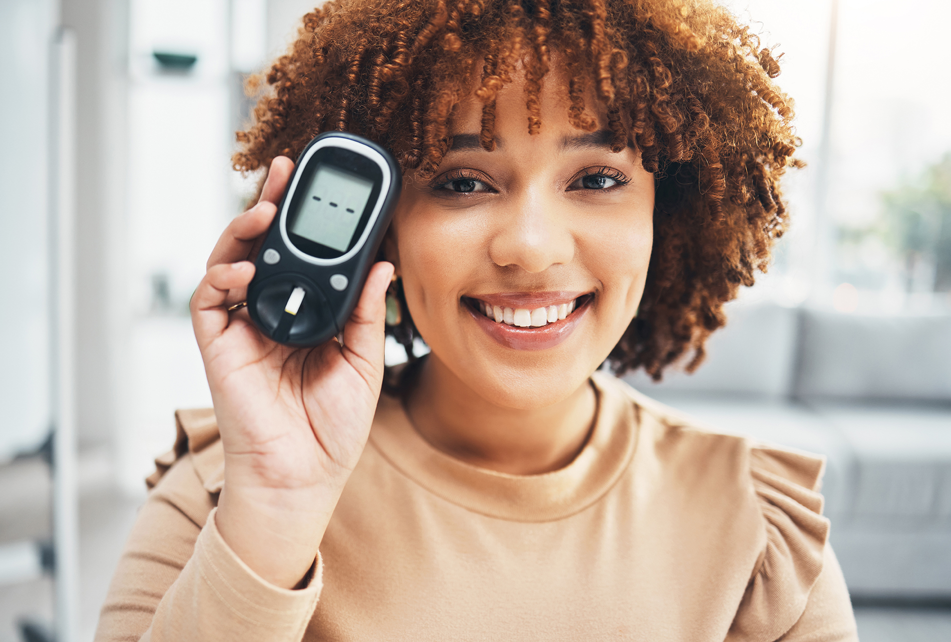 Young black woman holding a glucose monitor