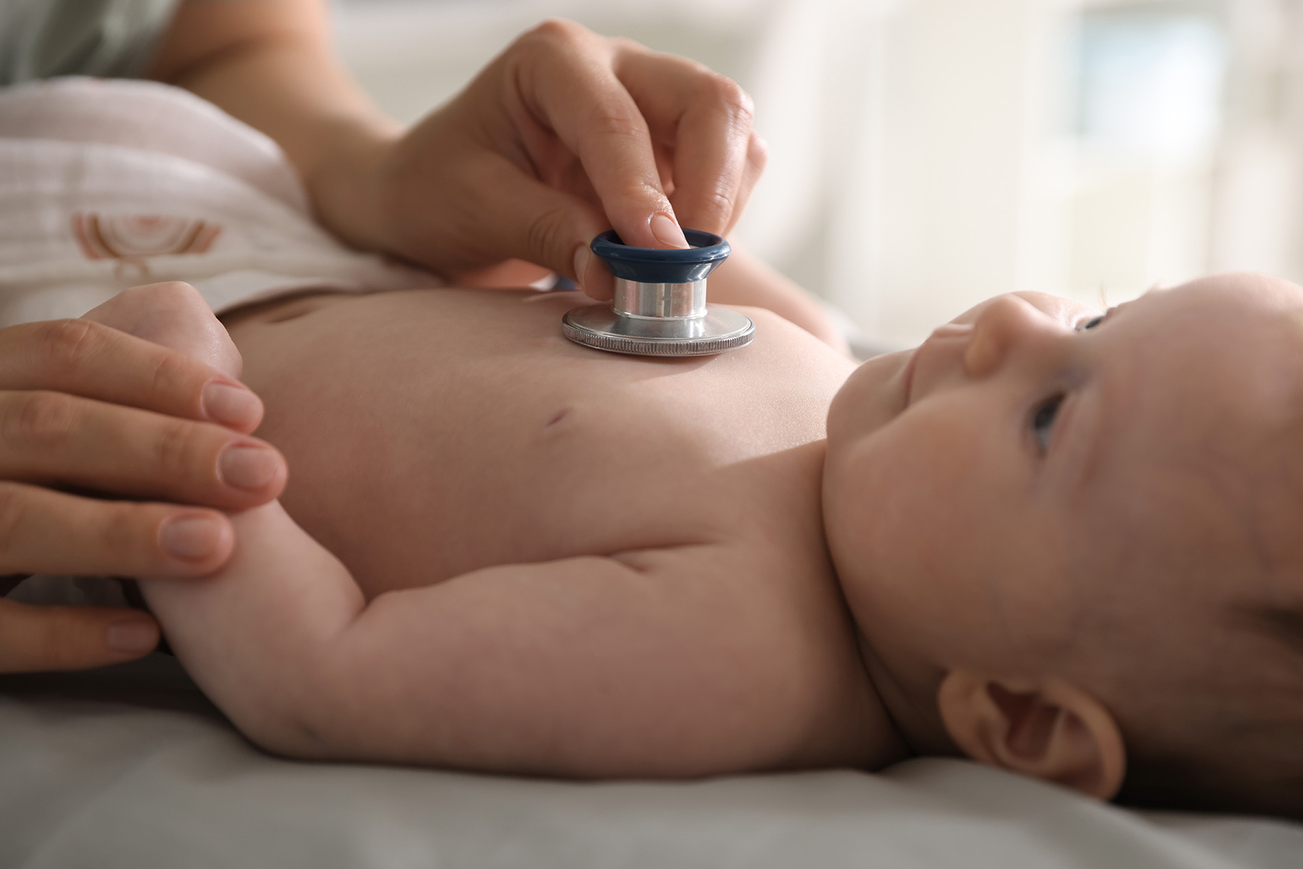 Close up photo of pediatrician examining infant