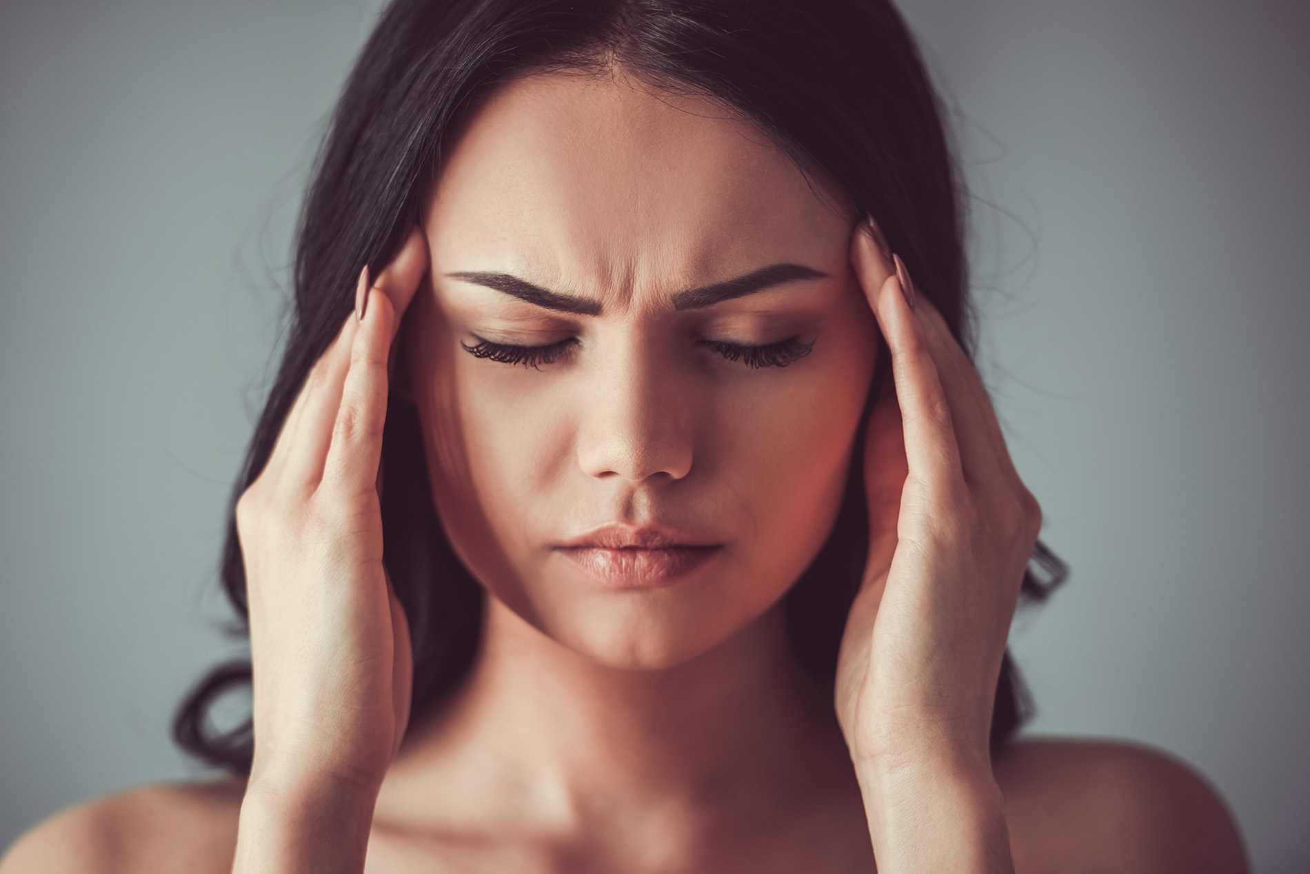 shutterstock_626243477 Woman with headache touching her temples