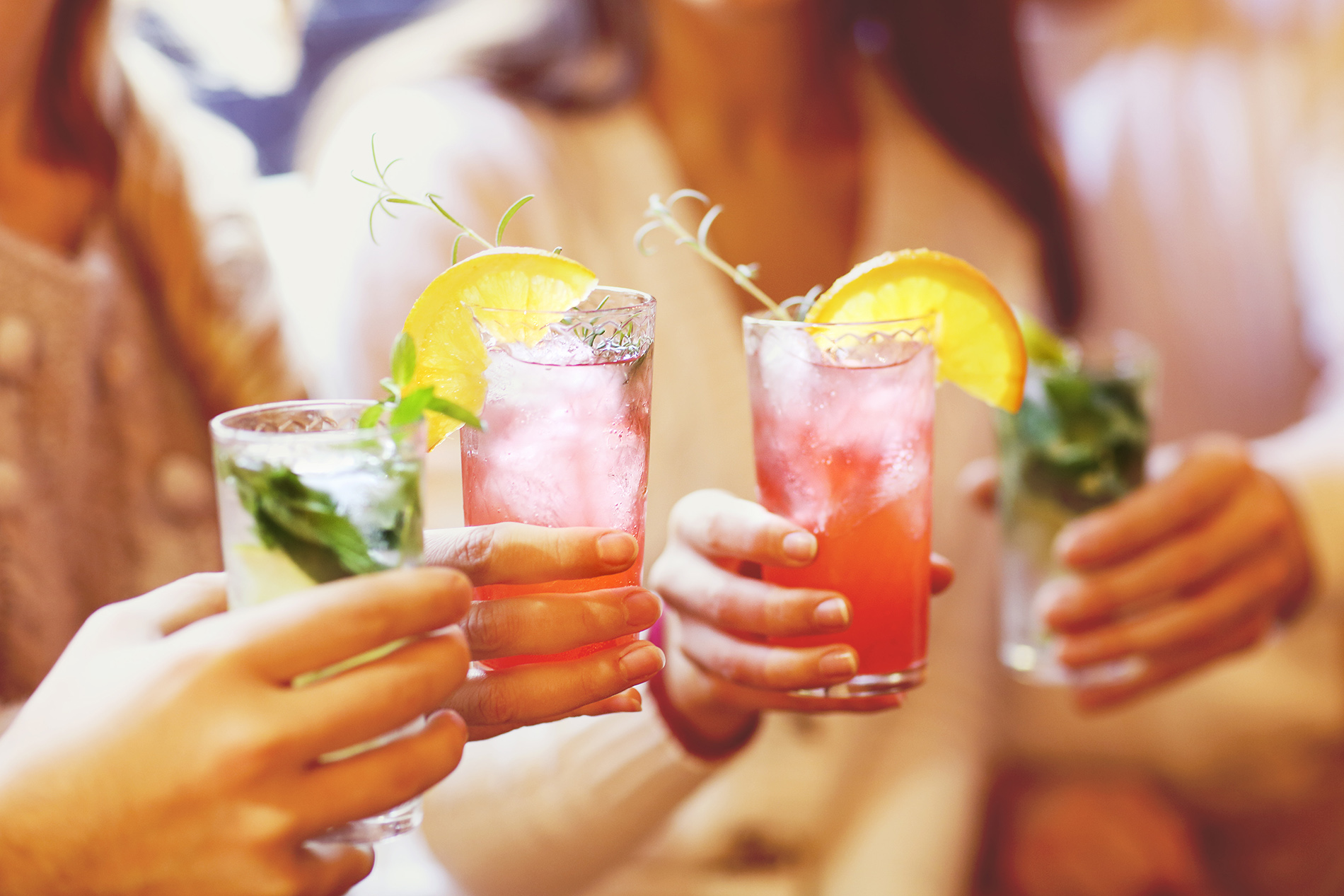 Four women clinking glasses of mocktails