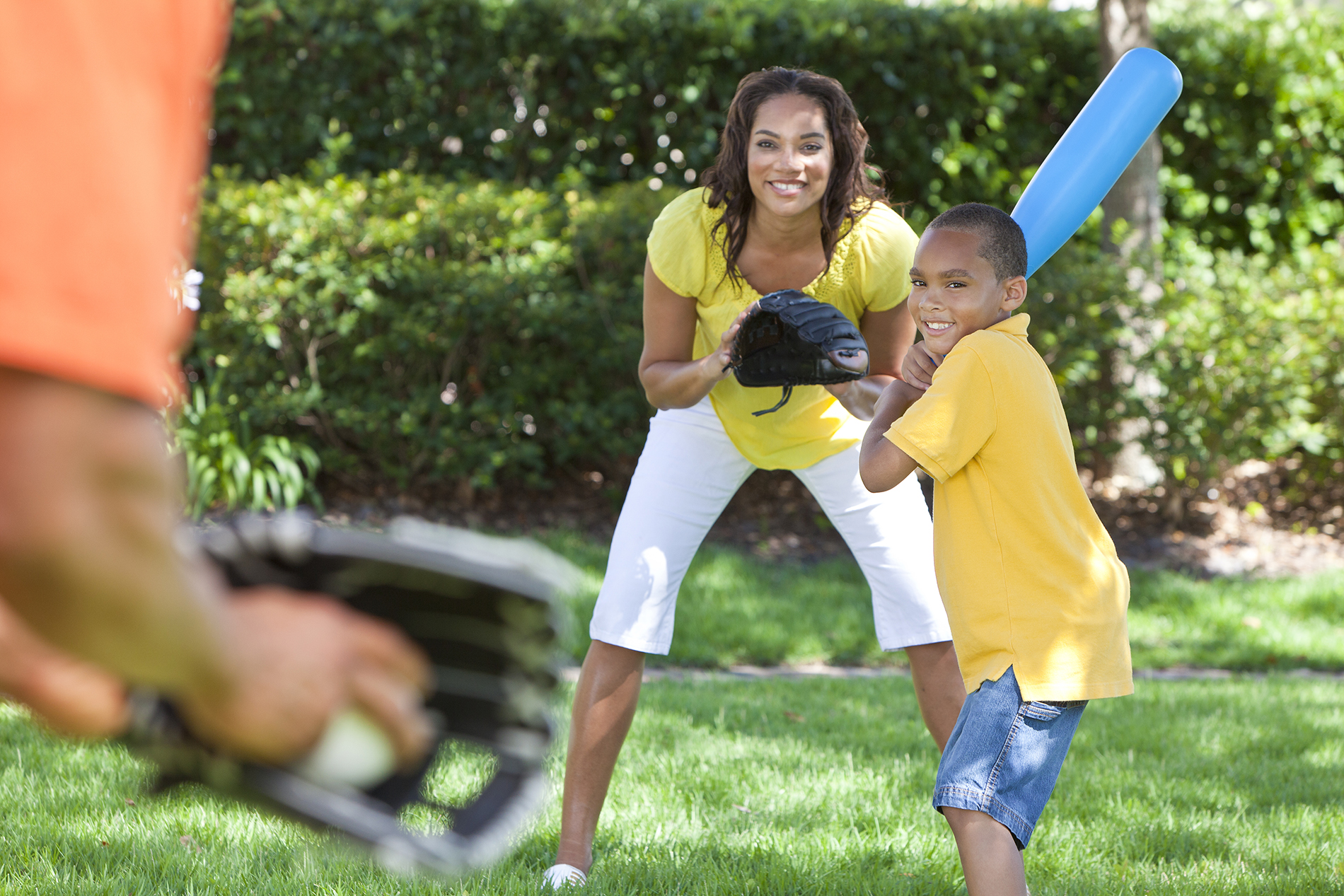 Woman playing baseball with husband and son