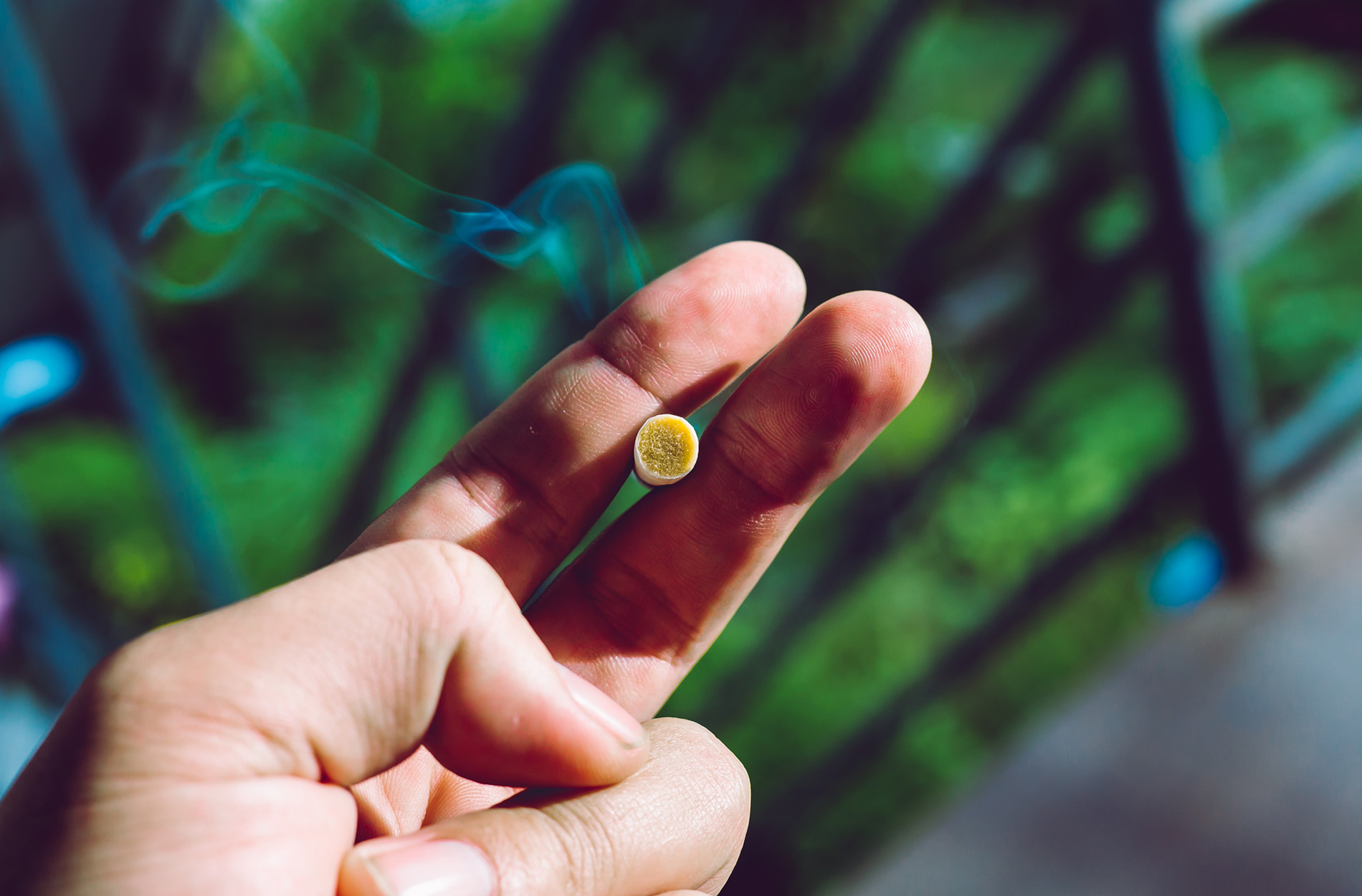 Hand holding a lit cigarette