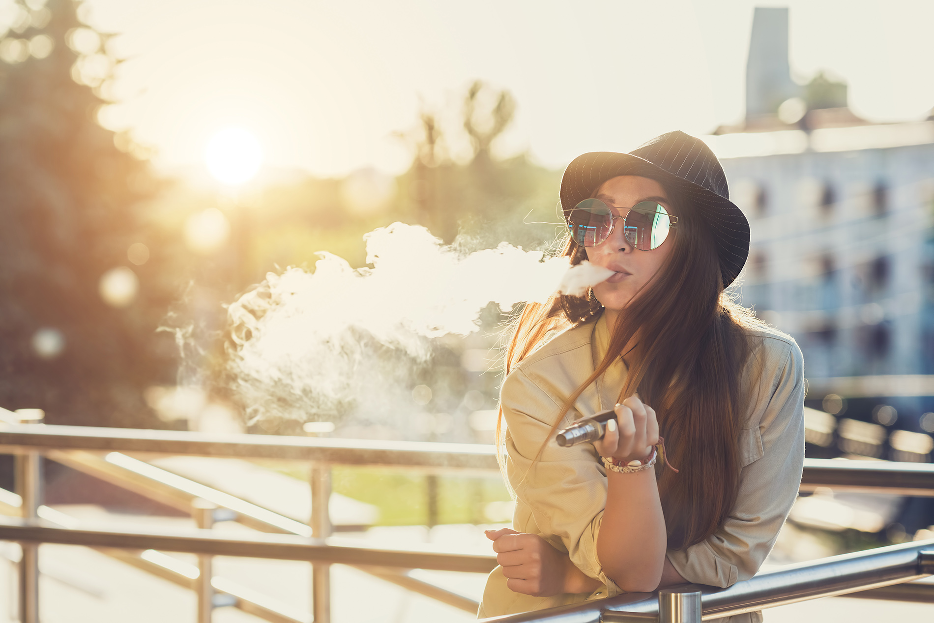 Young woman vaping outside