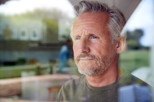Pensive man looking out window