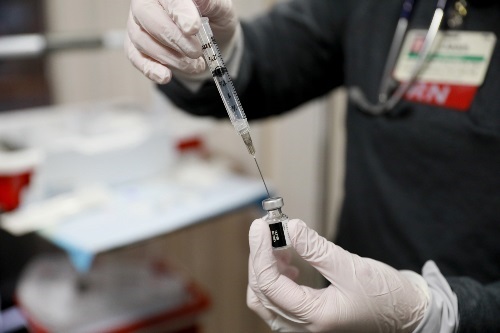 vaccine020 Nurse drawing vaccine from the vial into a syringe